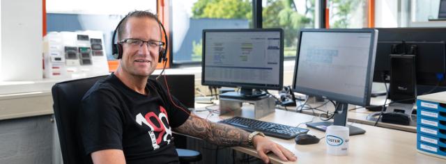 Service planner aan bureau met koptelefoon