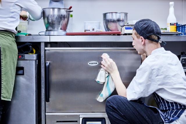 chef cleaning kitchen top table with G3 counters 