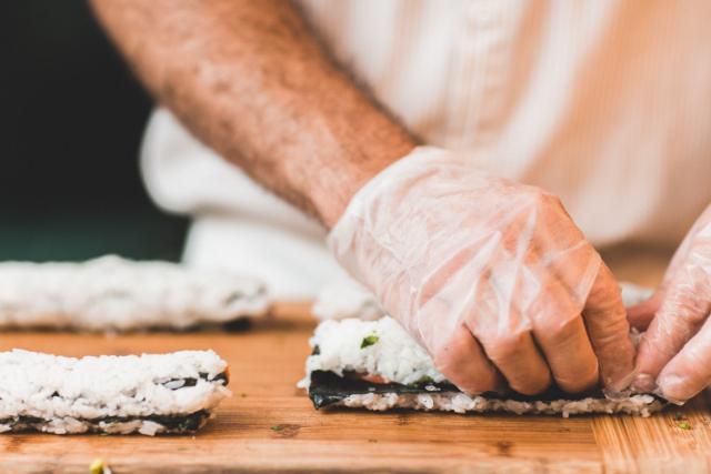 chef preparing sushi - rice rolls