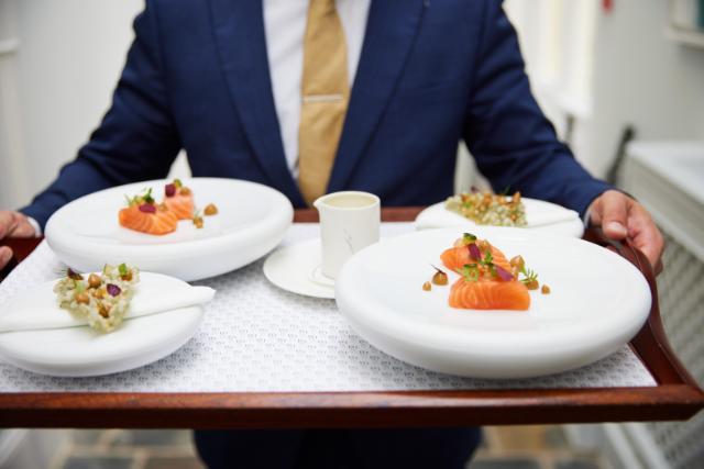 beautifully plated dishes are carried on a tray