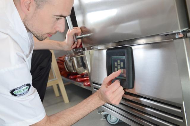Chef setting up temperature in Foster equipment