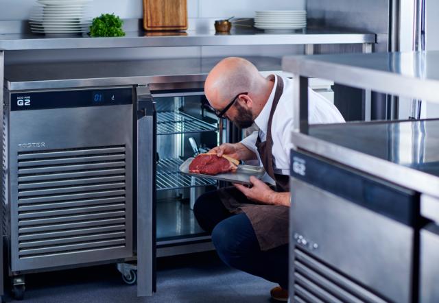 chef storing meet in a Foster counter fridge