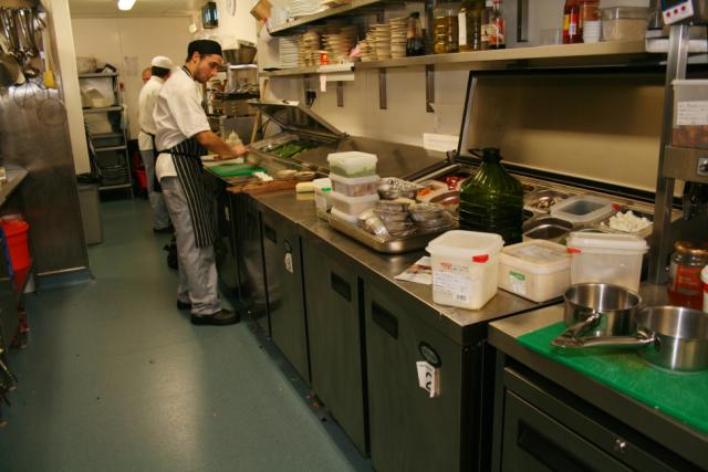 Kitchen environment with chef cooking and Foster Refrigerator equipment