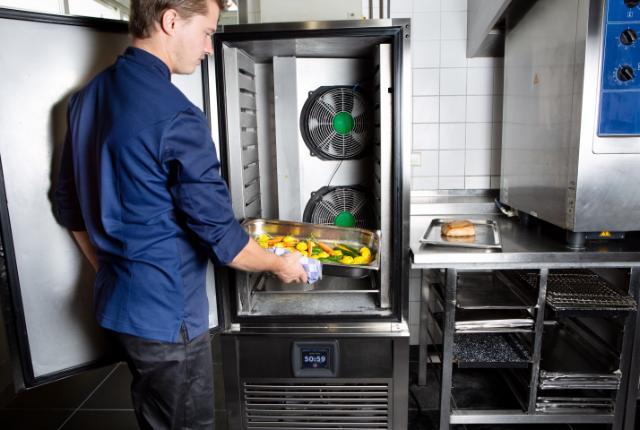 Chef storing food in Foster fridge cabinet