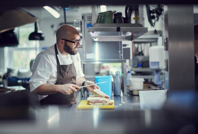 chef preparing fish in kitchen environment