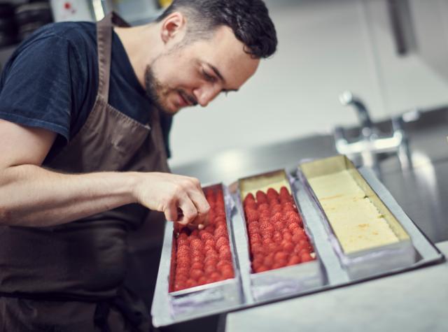 chef preparing pastry dessert with berries