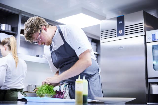 chef bereidt eten  met een Foster G3 koelkast in de achtergrond