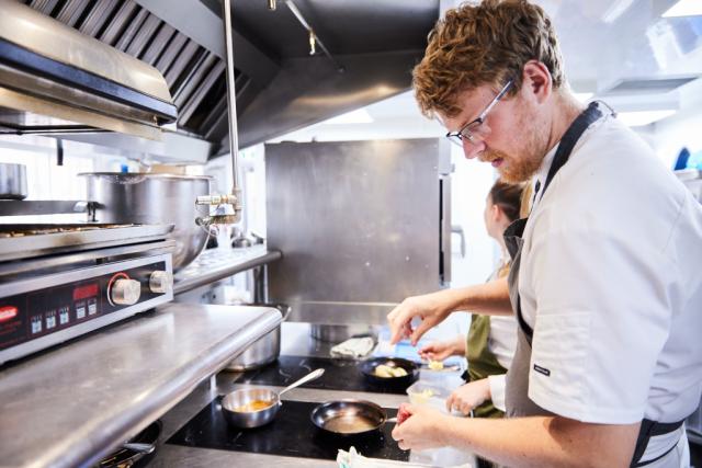 chefs aan het werken boven het fornuis