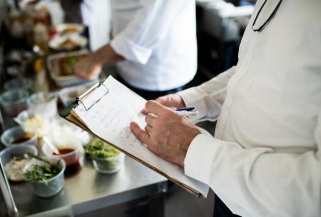 Chef holds clipboard