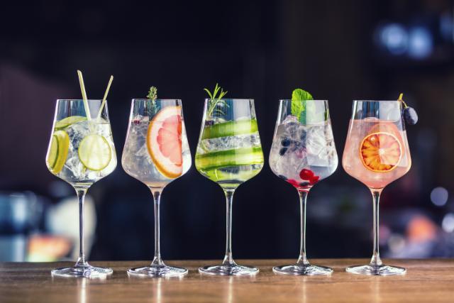 5 glasses filled with ice, drink and fruit